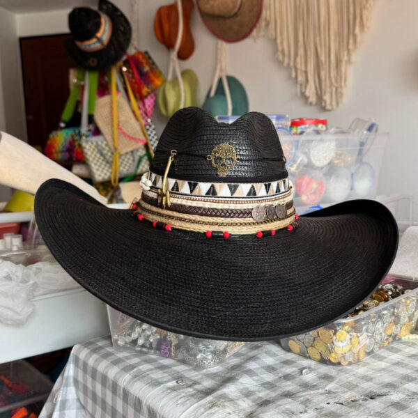 Sombrero Indiana negro decorado con calavera dorada, cintas tribales, monedas y detalles rojos – estilo rock artesanal para mujer, Sombrero Indiana Calavera Rock Black, sombreros de palma de iraca, sombreros decorados en colombia, sombreros personalizados de palma de iraca, sombreros artesanales con bordados, Hats made of Iraca palm