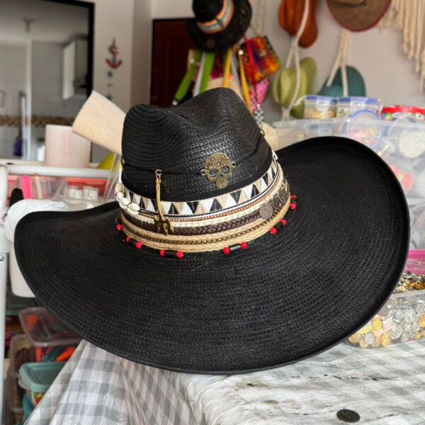 Sombrero Indiana negro decorado con calavera dorada, cintas tribales, monedas y detalles rojos – estilo rock artesanal para mujer, Sombrero Indiana Calavera Rock Black, sombreros de palma de iraca, sombreros decorados en colombia, sombreros personalizados de palma de iraca, sombreros artesanales con bordados, Hats made of Iraca palm