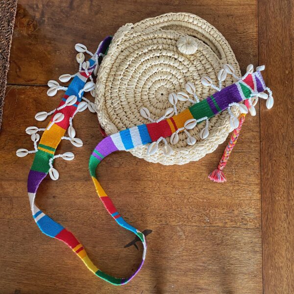 Bolso redondo tejido a mano con correa en telar guatemalteco y detalles de caracoles cauri – cartera cruzada artesanal colombiana única, diseño étnico vibrante, ideal para días de playa en verano, festivales al aire libre, vacaciones y outfits casuales. Milolita handwoven round boho bag with Guatemalan loom strap and cowrie shell accents – unique Colombian handmade crossbody purse, vibrant ethnic artisan design, perfect for summer beach days, outdoor festivals, vacations, and casual outfits., The Folky Snow Shell Bag, sombreros de palma de iraca, sombreros decorados en colombia, sombreros personalizados de palma de iraca, sombreros artesanales con bordados, Hats made of Iraca palm