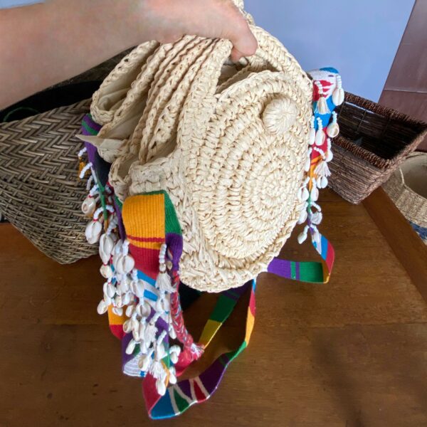 Bolso redondo artesanal con correa en telar guatemalteco y decoración de caracoles cauri – cartera cruzada colombiana hecha a mano, diseño resistente y elegante, ideal para outfits de verano, días de playa, viajes y festivales al aire libre. Milolita handmade round boho crossbody bag with Guatemalan loom strap and cowrie shell decoration – Colombian artisan purse, durable and stylish design, ideal for summer outfits, beach days, travel, and outdoor festivals.